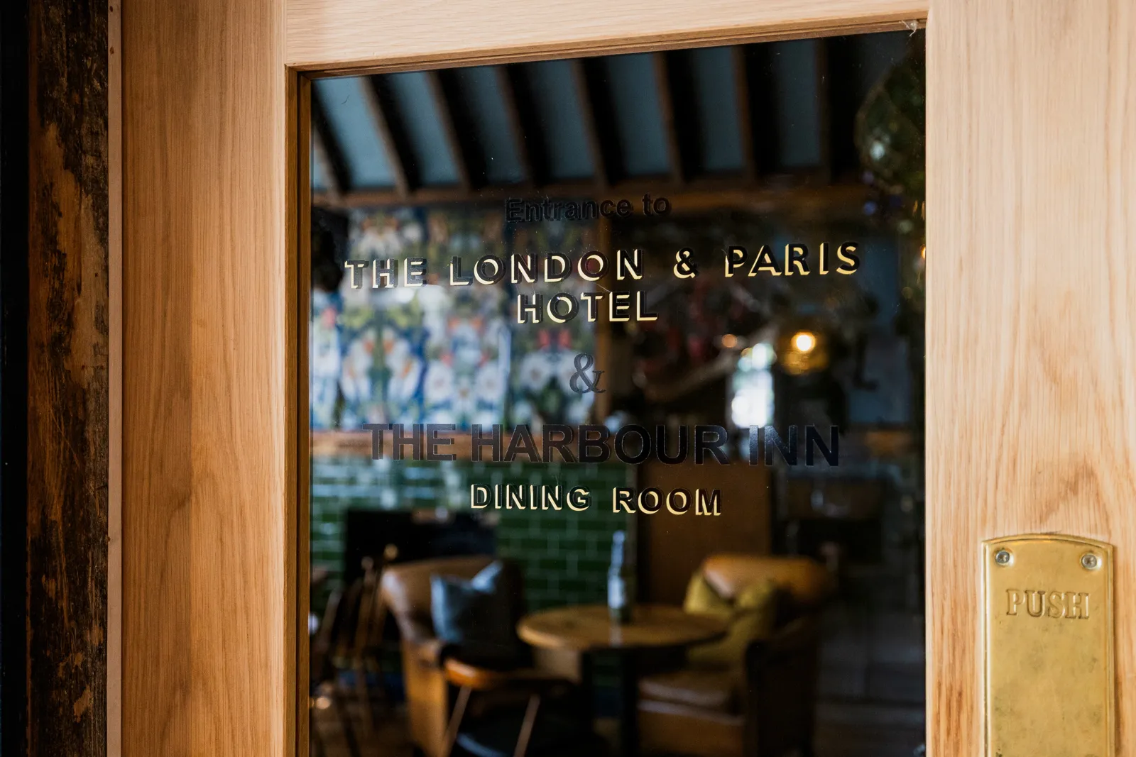 Glass doors etched with 'London & Paris Hotel' leading into the dining room