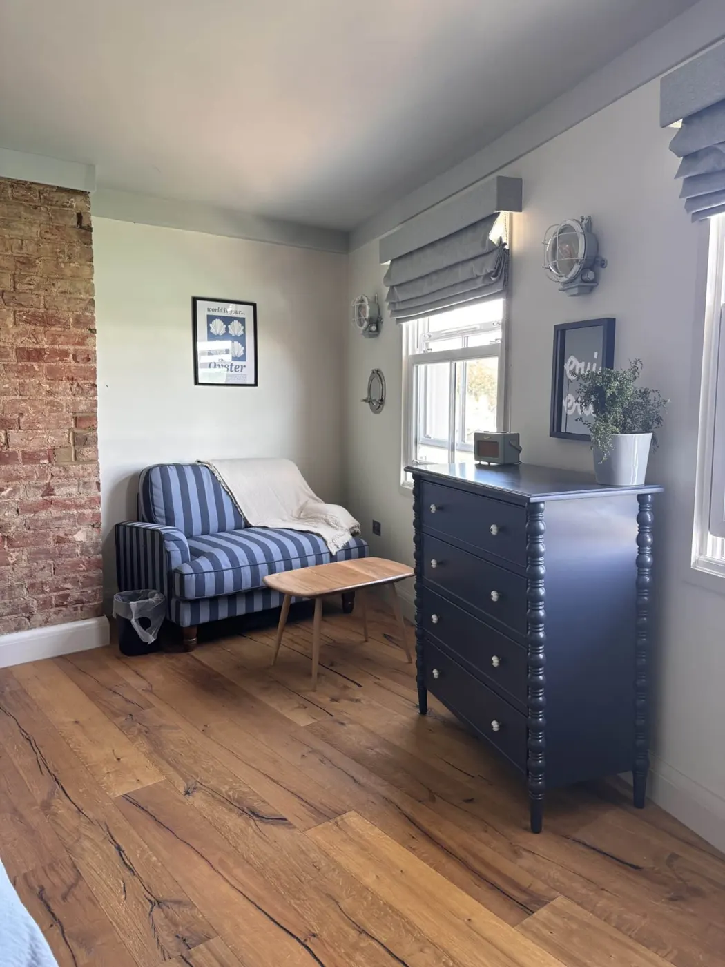 Room 10: a striped armchair and a navy chest of drawers by the window