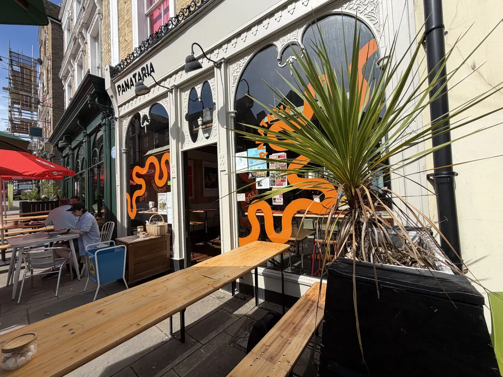 Panataria's frontage with orange wave signage and outdoor benches