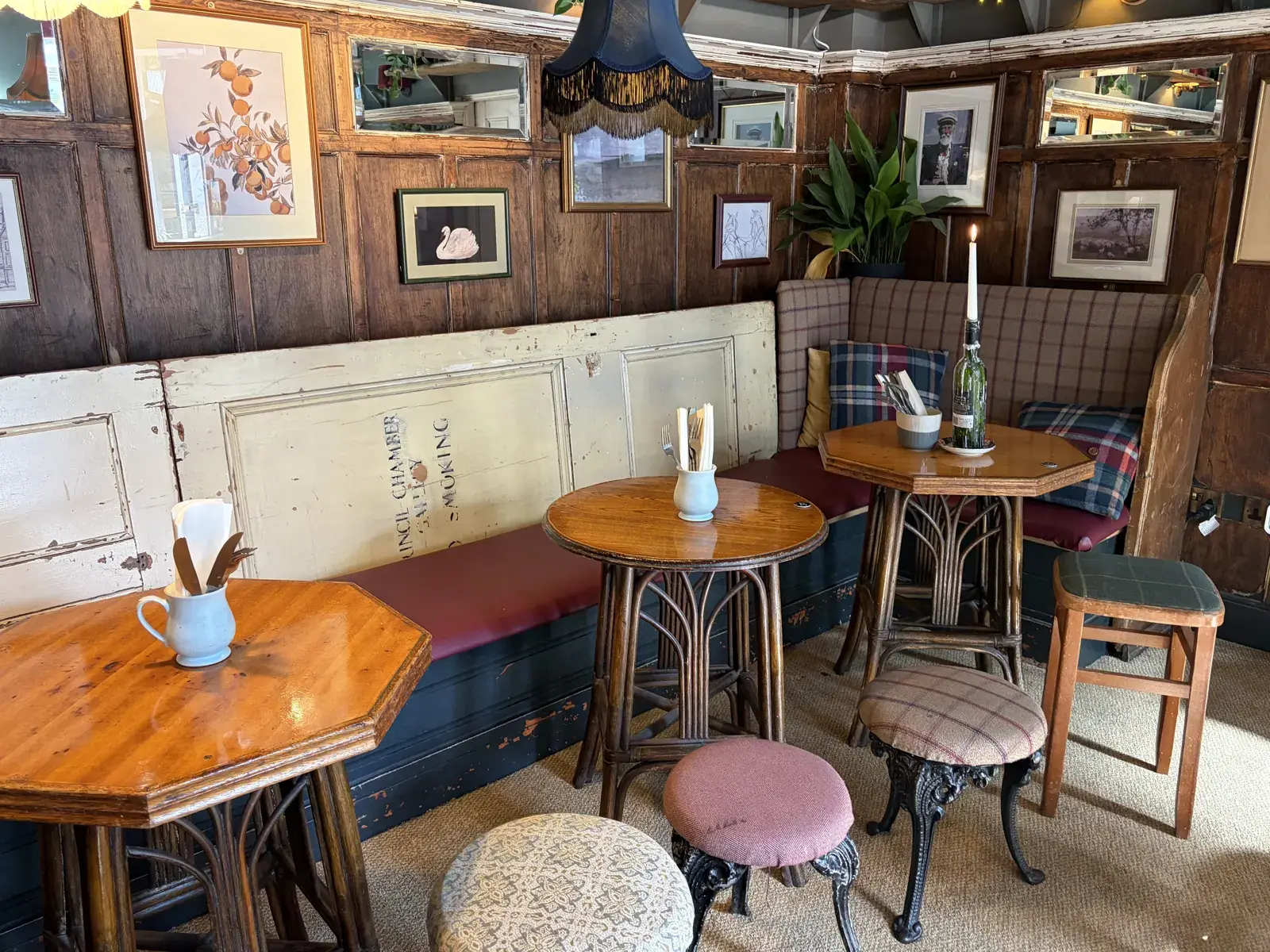 The Pullman bar room with wooden tables and hanging lamps