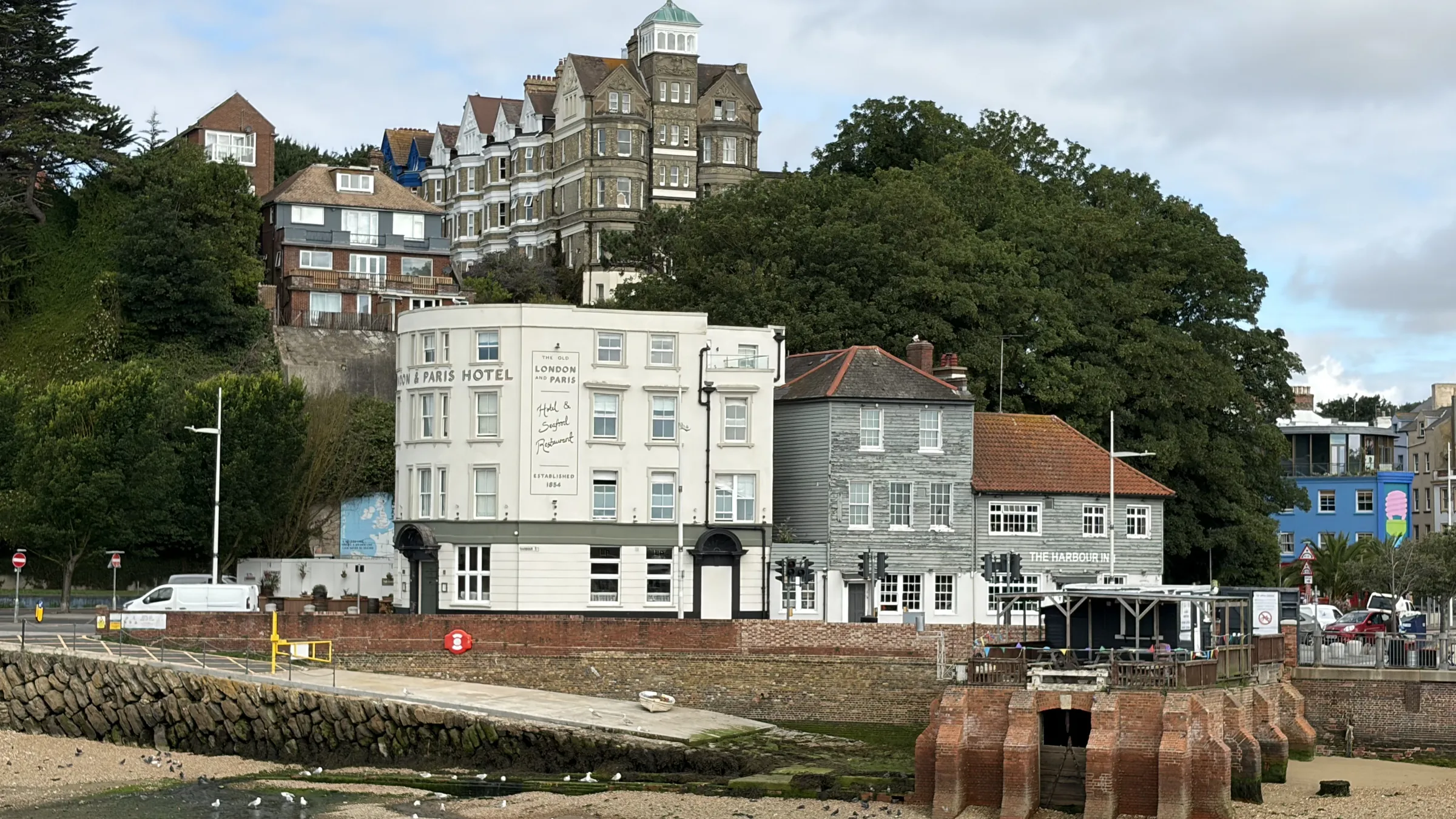 The London & Paris Hotel and The Harbour Inn side by side across the harbour, with the Grand Burstin above